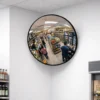 600mm Vista Flex indoor convex mirror mounted in a shop corner, reflecting retail aisles, stocked shelves, and shoppers for improved visibility at blind spots
